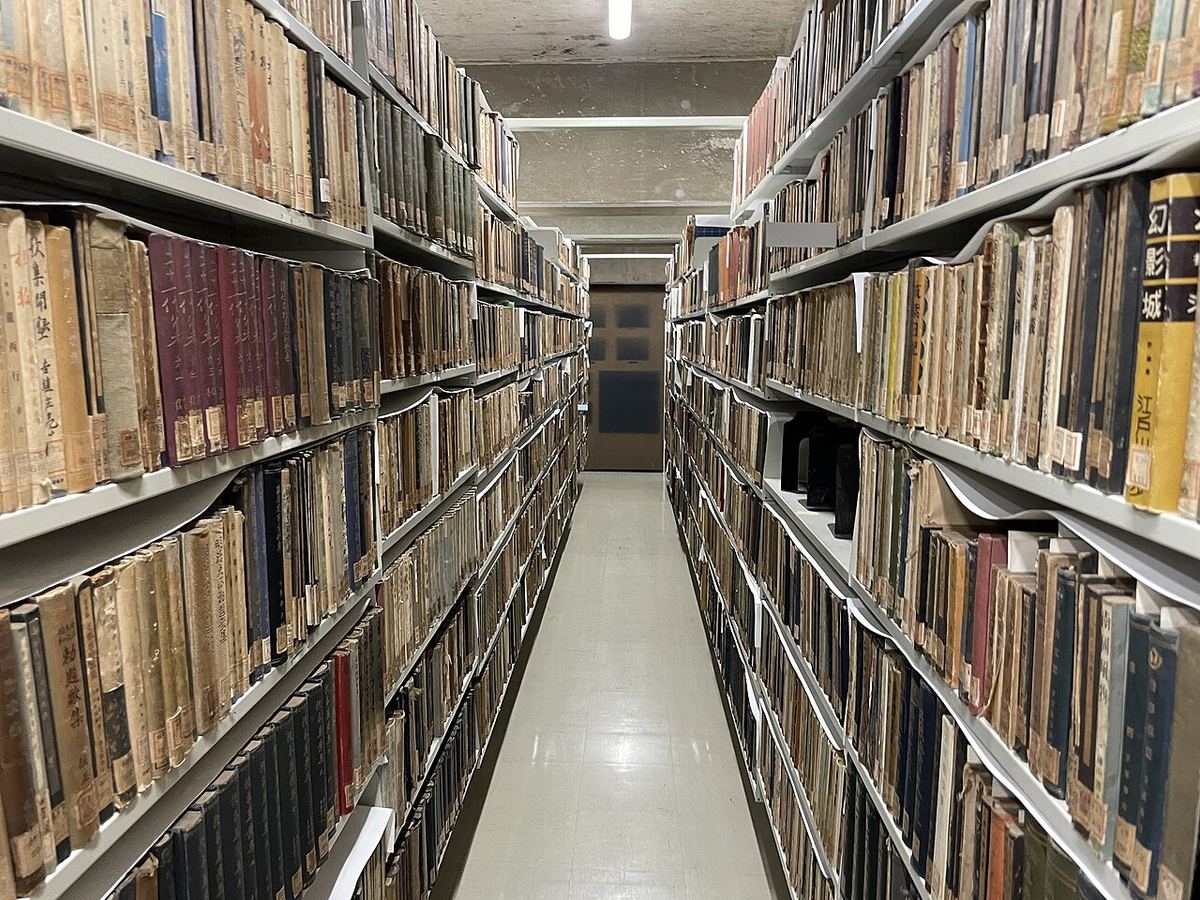 Lange gang tussen hoge boekenkasten vol boeken