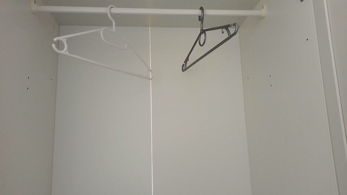 Bijna lege kledingkast met een paar lege kleerhangers