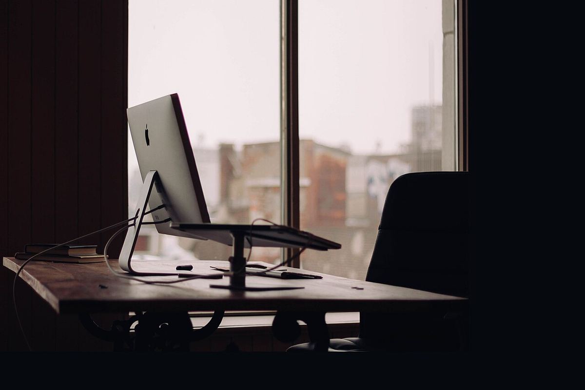Donker bureau met een computer voor een raam
